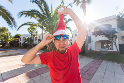 Portrait of smiling young man with palm trees