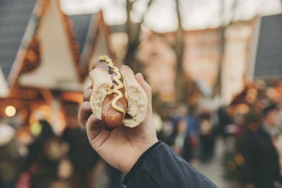 Hand of a man holding a bratwurst on the christmas market