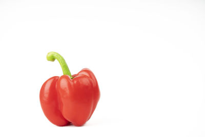 Close-up of red bell peppers against white background