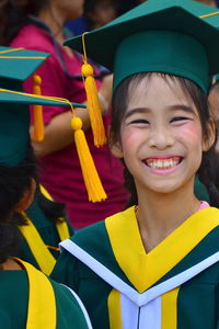 Portrait of smiling girl wearing graduation gown during event