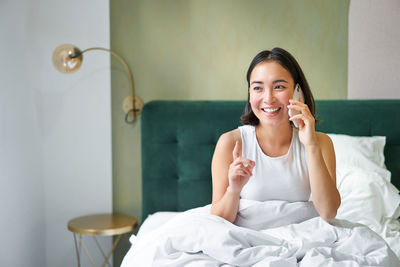 Young woman using mobile phone at home