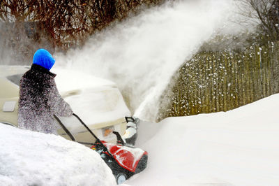 Rear view of person walking on snow covered land