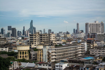 Aerial view of buildings in city against sky