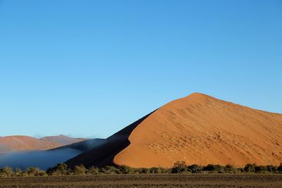 Scenic view of desert against clear blue sky