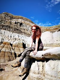 Portrait of young woman sitting on rock