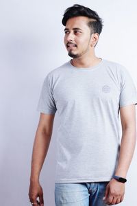 Portrait of young man standing against white background