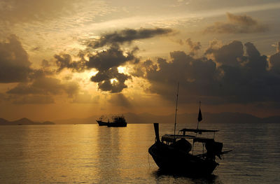 Silhouette of boats in sea during sunset