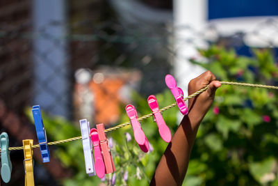 Cropped hand holding clothesline