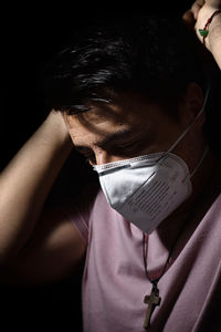 Close-up portrait of a young man covering face