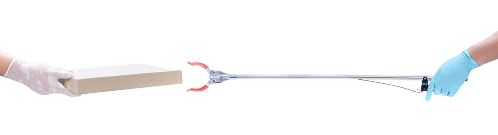Close-up of hand holding umbrella over white background