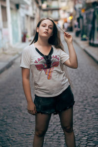 Beautiful young woman standing on street