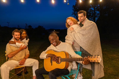 Portrait of smiling friends sitting on stage