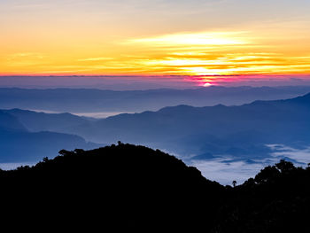 Scenic view of silhouette mountains against sky at sunset