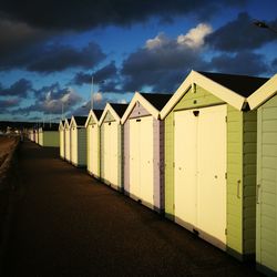 Beach huts against cloudy sky