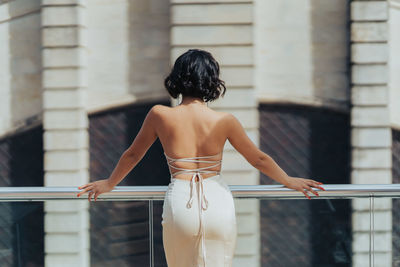 Rear view of young woman standing in city