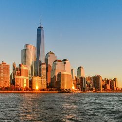 City at waterfront against blue sky