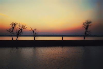 Scenic view of lake against orange sky