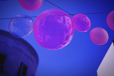 Low angle view of balloons against blue sky