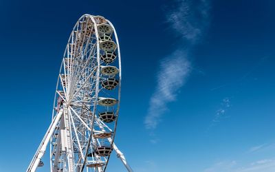 Low angle view of ferris wheel against blue sky