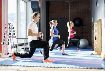 People exercising with kettlebells at gym