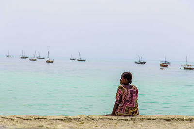 Rear view of woman looking at sea against sky