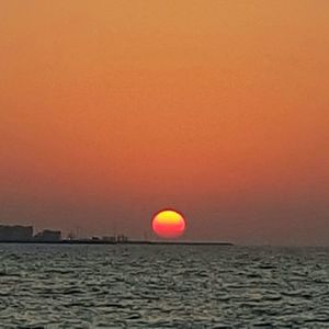 Scenic view of sea against orange sky