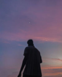 Rear view of silhouette man standing against sky during sunset