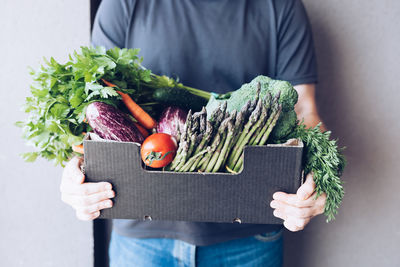 Midsection of man holding vegetables