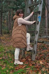 Full length of young woman standing in forest