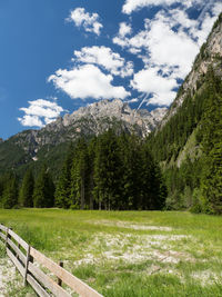 Scenic view of field by mountains against sky