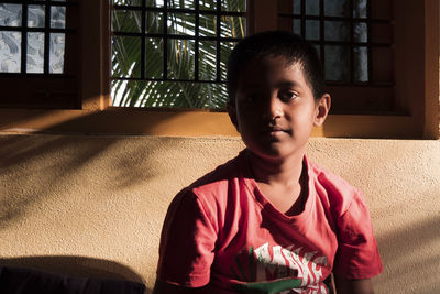 Portrait of boy sitting at home