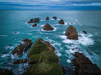 Rocks on sea shore against sky