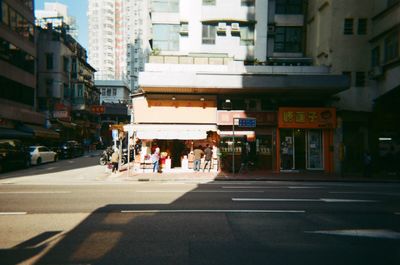 People crossing road against buildings in city