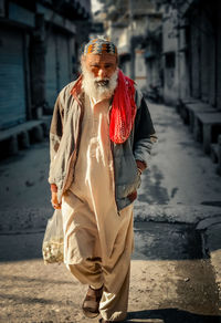 Portrait of man walking on street with some vegetables for there family.