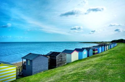 Beach huts by sea against sky