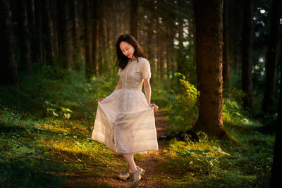 Young woman standing in forest