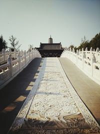 Walkway leading towards front of built structure against clear sky