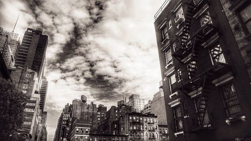 Low angle view of buildings against cloudy sky