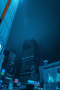 Low angle view of illuminated buildings against sky at night