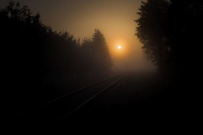 Railroad tracks against clear sky during sunset