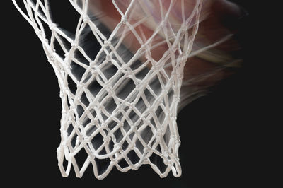 Close-up of basketball hoop against black backgrounds