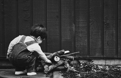 Full length of boy holding wood