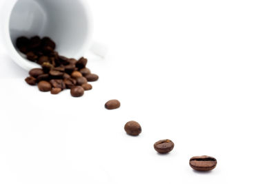 High angle view of coffee beans against white background