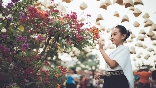 Woman standing by flowering plants