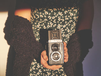 Midsection of woman holding camera