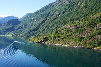Scenic view of lake by mountains against sky