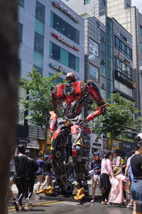 People on street against buildings in city