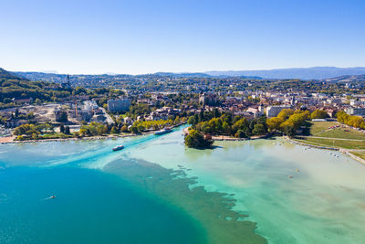 High angle view of townscape by sea against clear sky