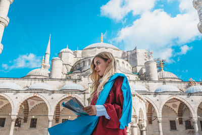 Woman standing against blue sky