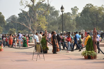 Group of people at street market against trees